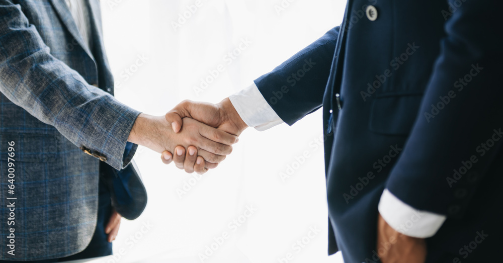 Obraz premium Business partnership handshake concept.Photo two coworkers handshaking process.Successful deal after great meeting. in office..