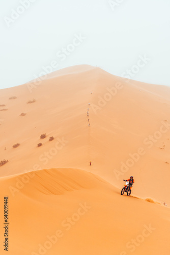 Motorbike racing through Sahara Desert, chebbi dune in Merzouga, Morocco