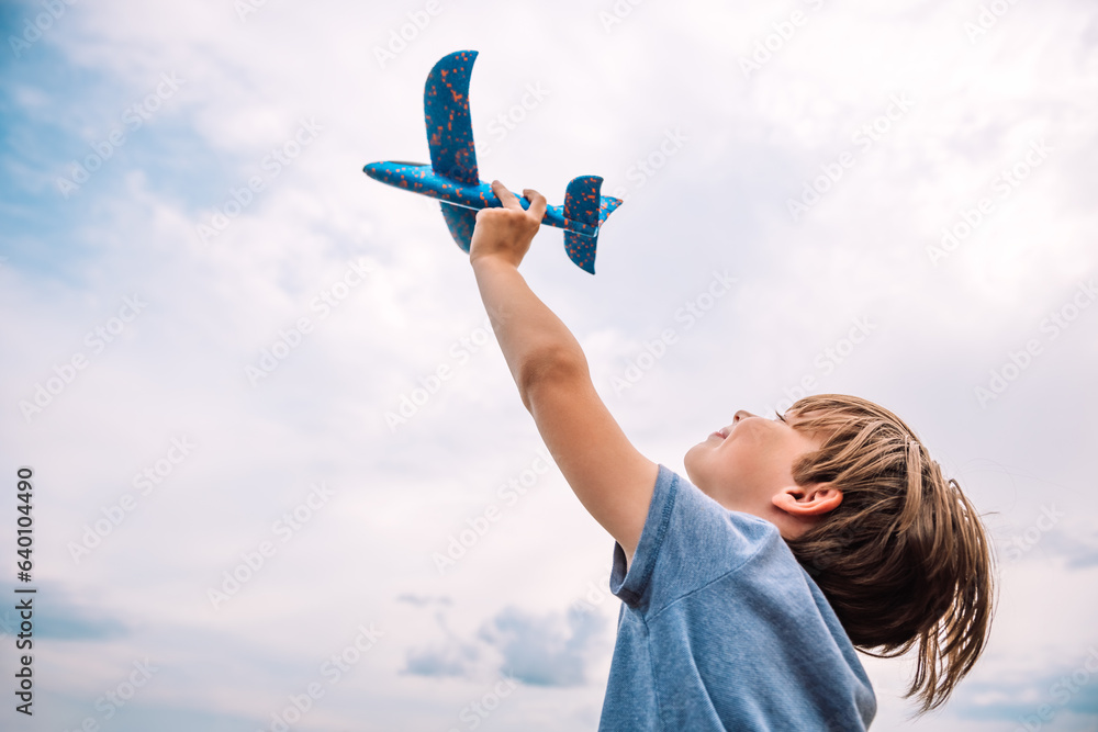 Child dream to fly. Happy boy child runs with toy plane. Boy kid playing aviator. Kid dream of becoming an astronaut. Child flight dream concept - obrazy, fototapety, plakaty 