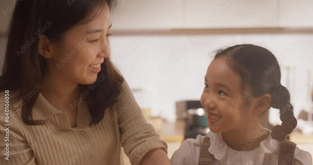 Korean Mother and Cute Little Daughter Cooking Together Healthy Dinner in their Home Kitchen. Adorable Little Girl Helping her Mom With Making a Salad. They are Talking and Bonding Korean Mother and Cute Little Daughter Cooking Together Healthy Dinner in their Home Kitchen. Adorable Little Girl Helping her Mom With Making a Salad. They are Talking and Bonding