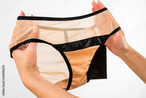 beige lace underwear bra in female hand, choose best hot lingerie