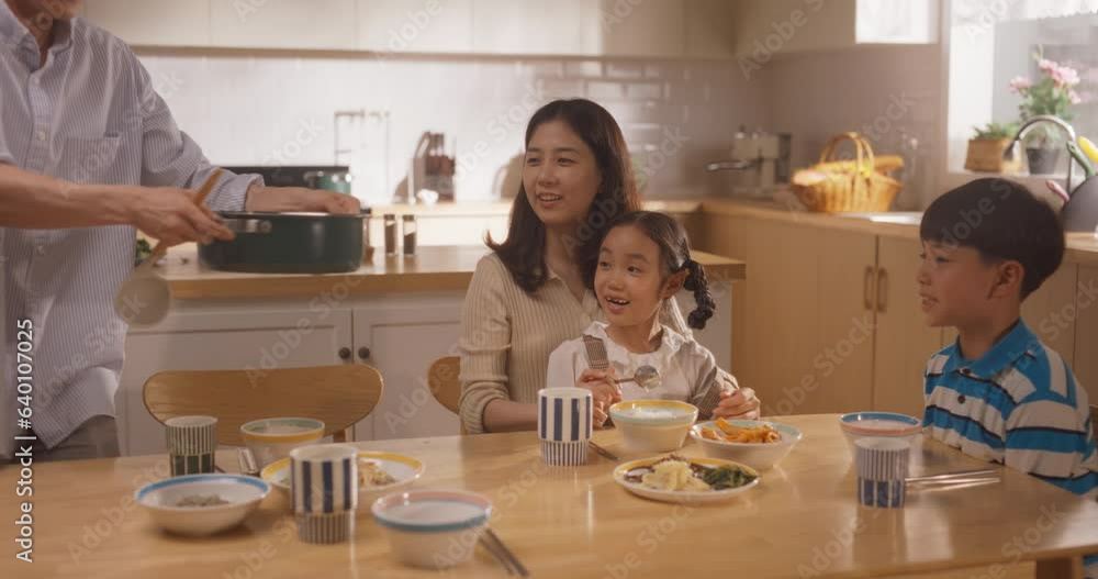 Happy Korean Family of Four Enjoying a Delicious Meal Together in Their Kitchen at Home. They are Sharing a Traditional Meal Made with Love and Care. Children Excited for Food Happy Korean Family of Four Enjoying a Delicious Meal Together in Their Kitchen at Home. They are Sharing a Traditional Meal Made with Love and Care. Children Excited for Food