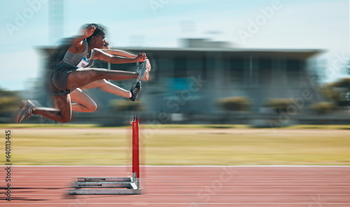 Fast, hurdles and team of women on track running in race, marathon or competition in stadium. Fitness, workout and female athletes jumping with speed and energy for outdoor training with blur motion. photo