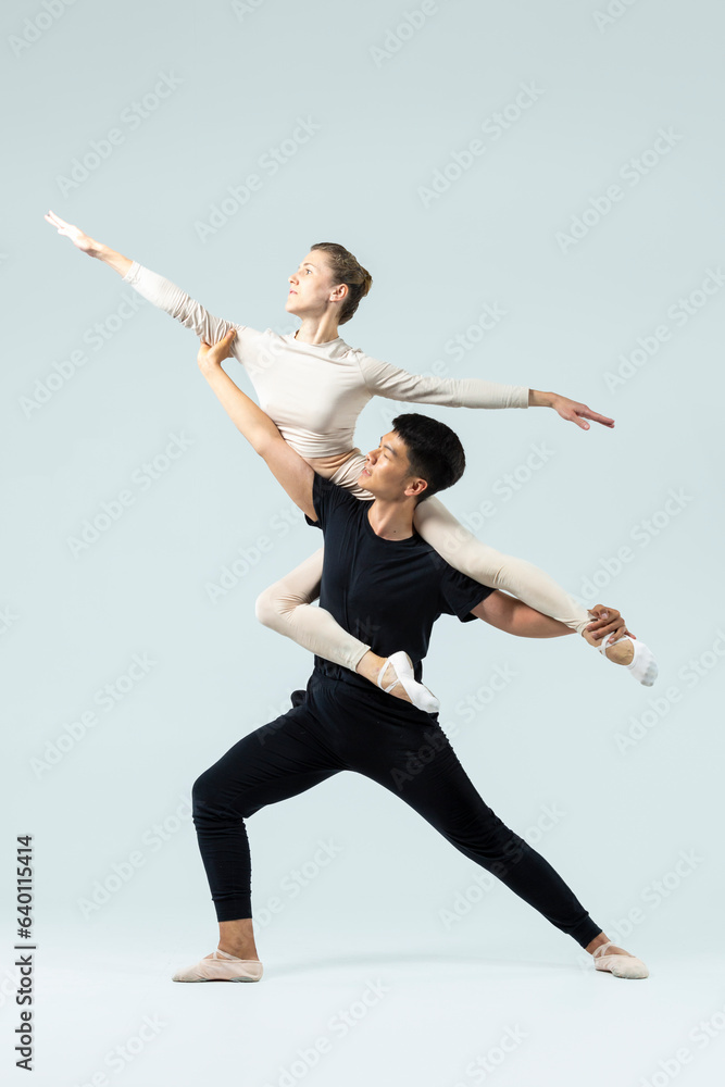 Obraz premium Ballet Ideas. Asian Young Man and Caucasian Woman Performing As Ballet Dancers Over Grey in Studio During Suppots As Classical Dance Aesthetics With Choreography Art