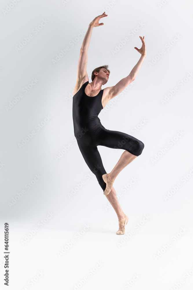 Professional Male Ballet Dancer Young Athletic Man in Black Suit Posing in Ballanced Dance Pose Studio On White. Professional Male Ballet Dancer Young Athletic Man in Black Suit Posing in Ballanced Dance Pose Studio On White.