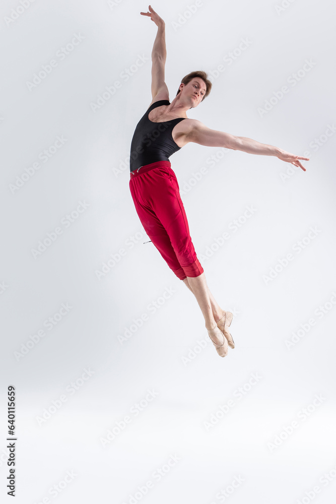 Flying Ballet Dancer. Contemporary Art Ballet With Young Flexible Athletic Man Posing in Flying Dance Pose in Studio on White