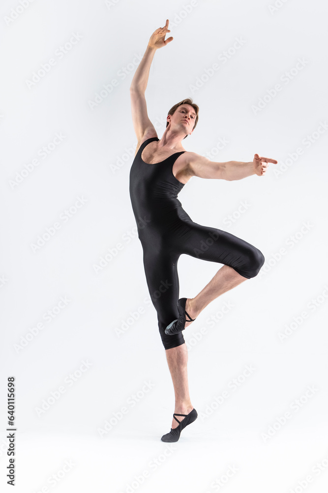 Sportive Caucasian Male Ballet Dancer Flexible Athletic Man Posing in Black Tights in Ballanced Dance Pose With Hands and Leg Lifted