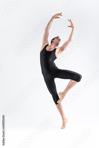 Professional Ballet Dancer Young Athletic Man in Black Suit Posing in Ballanced Dance Pose Studio On White. photo