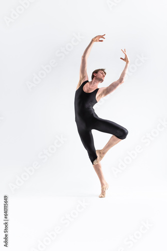Fototapeta Naklejka Na Ścianę i Meble -  Ballet Dancer Young Man in Black Dance Suit Posing in Ballanced Dance Pose Studio On White.