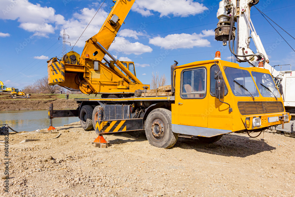 Mobile crane and drilling machine working together on bridge foundation Mobile crane and drilling machine working together on bridge foundation