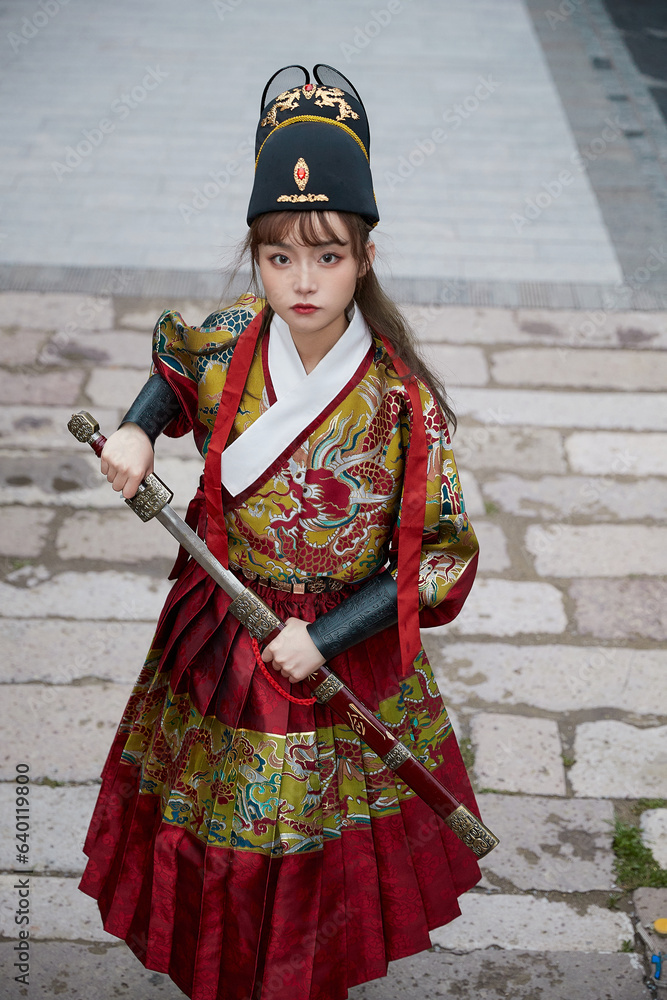 An Oriental beauty dressed in ancient warrior attire, wielding a weapon