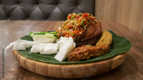 Fried chicken with Easy Sambal Matah Bali or Balinese Raw Sambal, traditional Indonesian food with mix raw mash chili, lemon grass stalks, shallots, garlic, kafir limes, shrimp paste and cooking oil. photo