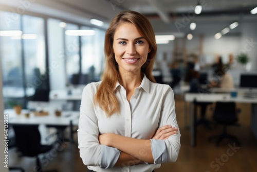 Smiling female hr specialist employee posing with arms crossed standing in contemporary office
