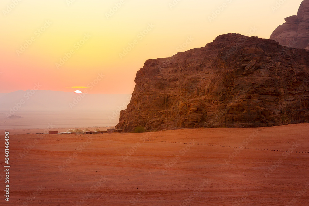 Jordan, Wadi Rum sun appears over horizon, sunrise in the desert, camp tents