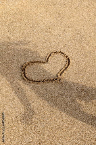 Capture love's fleeting beauty with 'Heart in Sardinian Sands.' This portrait shot features a hand-drawn heart in wet Sardinian sand, freshly kissed by retreating waves. 