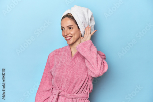 Woman in pink robe after shower trying to listening a gossip.