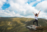 A beautiful woman practices meditation exercises and poses in a spectacular mountain scenery. Free and independent woman - concept.