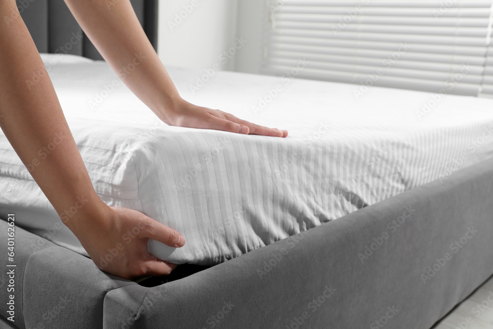 Woman touching soft mattress indoors, closeup view Woman touching soft mattress indoors, closeup view