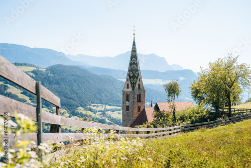 Church on a mountain overlooking valley in Villandro, Dolomites, Italy photo