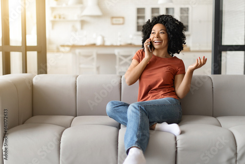 Making Call. Cheerful Young Black Woman Talking On Cellphone At Home