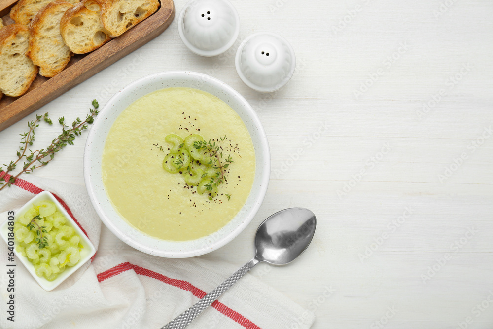 Bowl of delicious celery soup served on white wooden table, flat lay. Space for text Bowl of delicious celery soup served on white wooden table, flat lay. Space for text