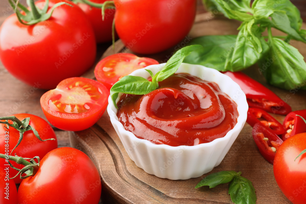 Bowl of tasty ketchup and ingredients on wooden table, closeup Bowl of tasty ketchup and ingredients on wooden table, closeup