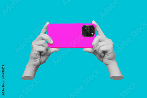 Mobile phone with photo camera in female hands isolated on blue background. Mockup of smartphone. Young woman takes picture. Trendy collage in magazine style. Contemporary art. Modern creative design