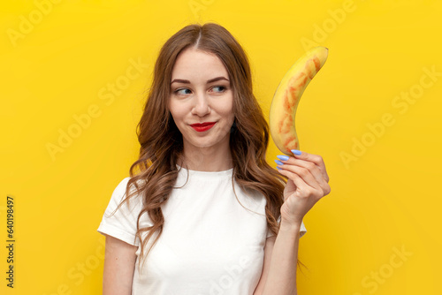 Photos young girl shows kissed banana and hints at intimacy on yellow isolated backgrou