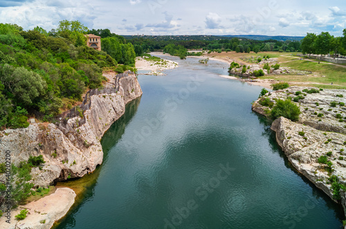 Panoramic view of River Gardon seen from ancient old Roman Aqueduct Pont du Gard ear Vers-Pon-du-Gard, Occitanie, France, Europe. Unesco world heritage site near Nimes, Languedoc-Roussillon