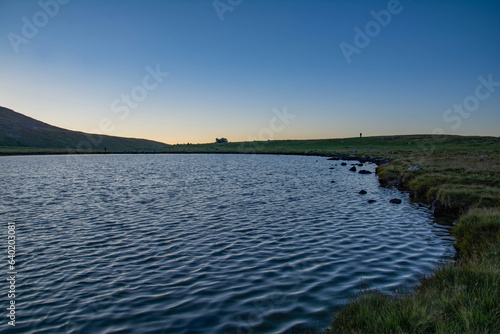 Small lake on top of a mountain. Crystal clear lake and mountain. Beautiful landscape with lake, fields and mountain