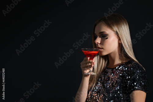 A girl at a party in the style of Halloween with a cocktail in her hands