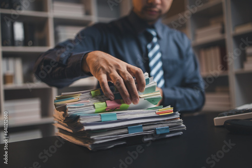 Tableau sur toile Startup company employees are rummaging through piles of paperwork for performance summaries, employees working overtime and working hard