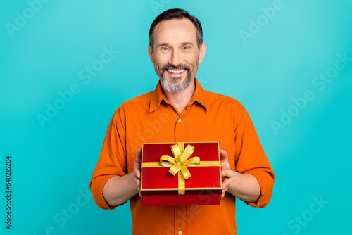 Photo of businessman pensioner holding receive red gift box with ribbon new present birthday isolated on aquamarine color background © deagreez