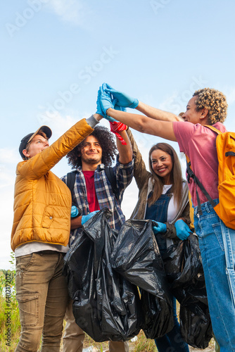Celebrate the spirit of environmental stewardship and camaraderie in this dynamic image. A diverse group of young volunteers from different ethnic backgrounds unite to clean up the forest. With high