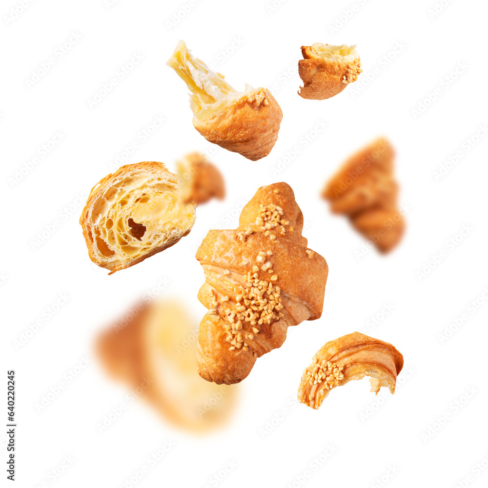 Creative bakery food background, croissant sprinkled with nuts. Cut out flying whole and broken fresh croissant with butter cream isolated on white background. With clipping path