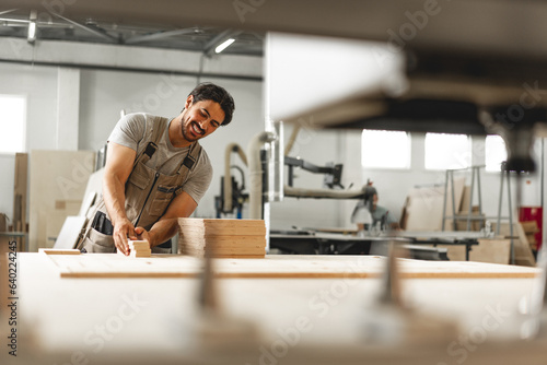 Young man doing woodwork in carpentry factory