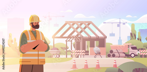 architect or engineer in uniform standing near unfinished building construction site background
