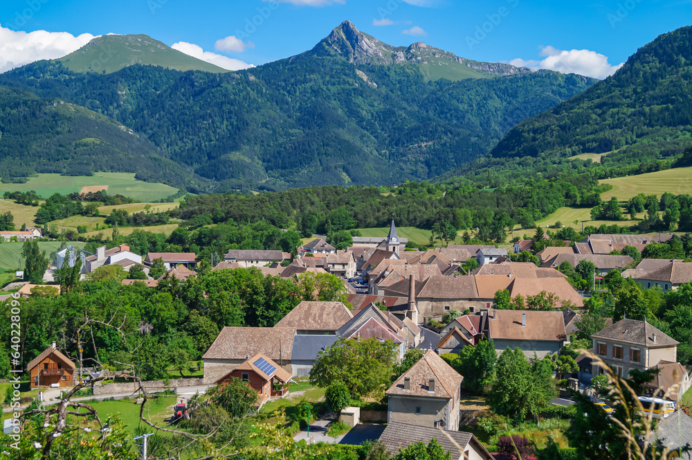 Beautiful French village against the background of mountains and blue sky in the Alps of Haute-Provence. Scenic view of Isère, the Percy village Trièves, Regional Natural Park of Vercors