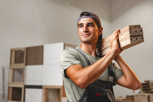 Portrait of young male carpenter standing in the wood workshop photo