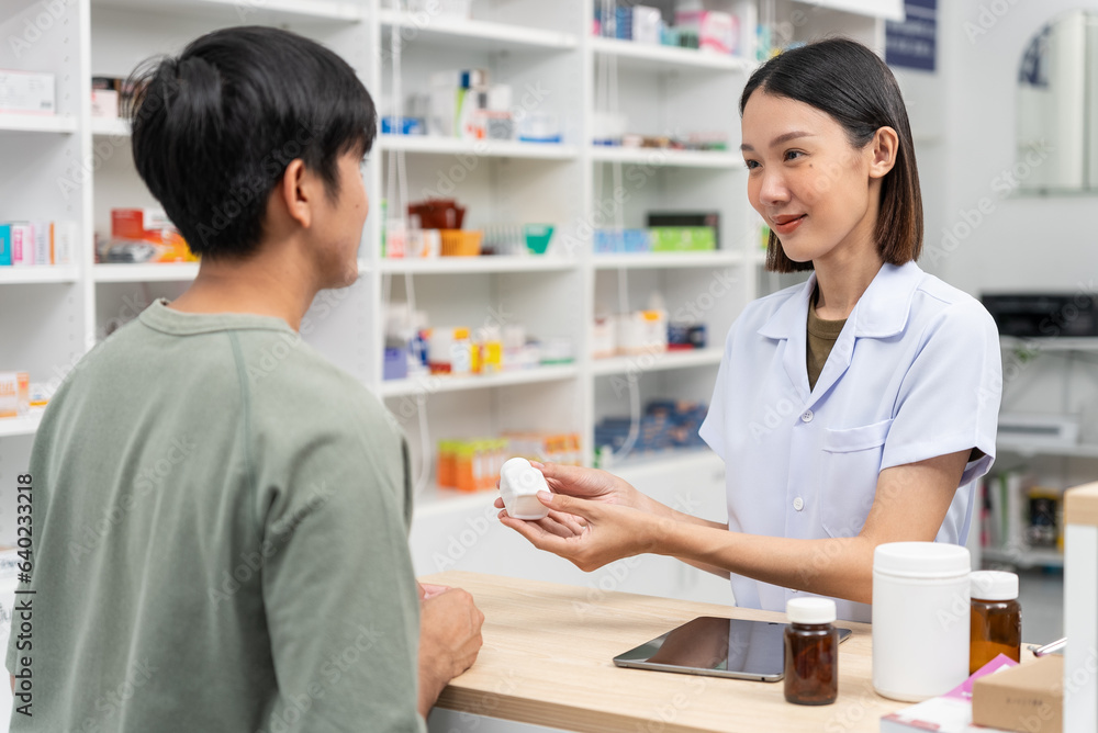 Beautiful asian female pharmacist analyzing about customer symptoms for discussion of the medicine property effect and customer buying pill under prescription order. Beautiful asian female pharmacist analyzing about customer symptoms for discussion of the medicine property effect and customer buying pill under prescription order.