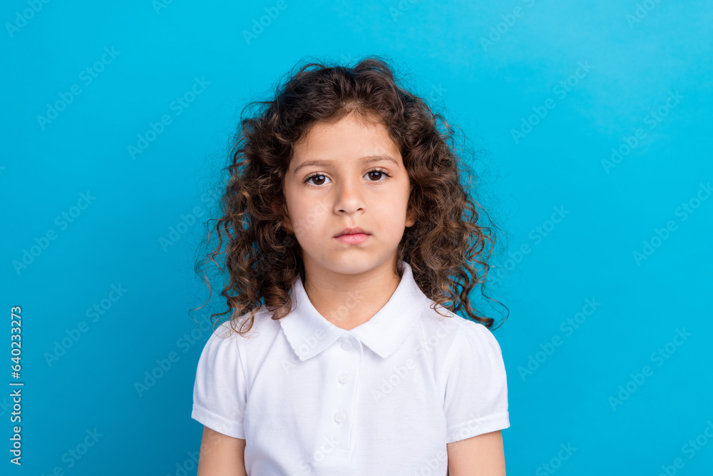 Portrait of charming pretty schoolchild looking in camera isolated over blue color background Portrait of charming pretty schoolchild looking in camera isolated over blue color background