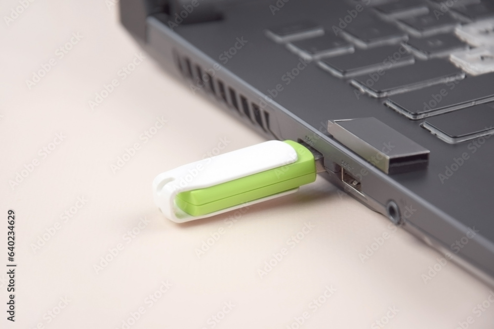 USB memory stick or flash drive on the keyboard of an open laptop. USB memory stick or flash drive on the keyboard of an open laptop.