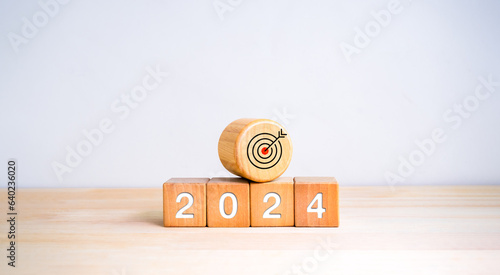 The calendar year 2024 with goal and success concept. Big wood target dart icon and 2024 new year number on wooden cube block isolated on white background. Happy new year, big business goals banner.