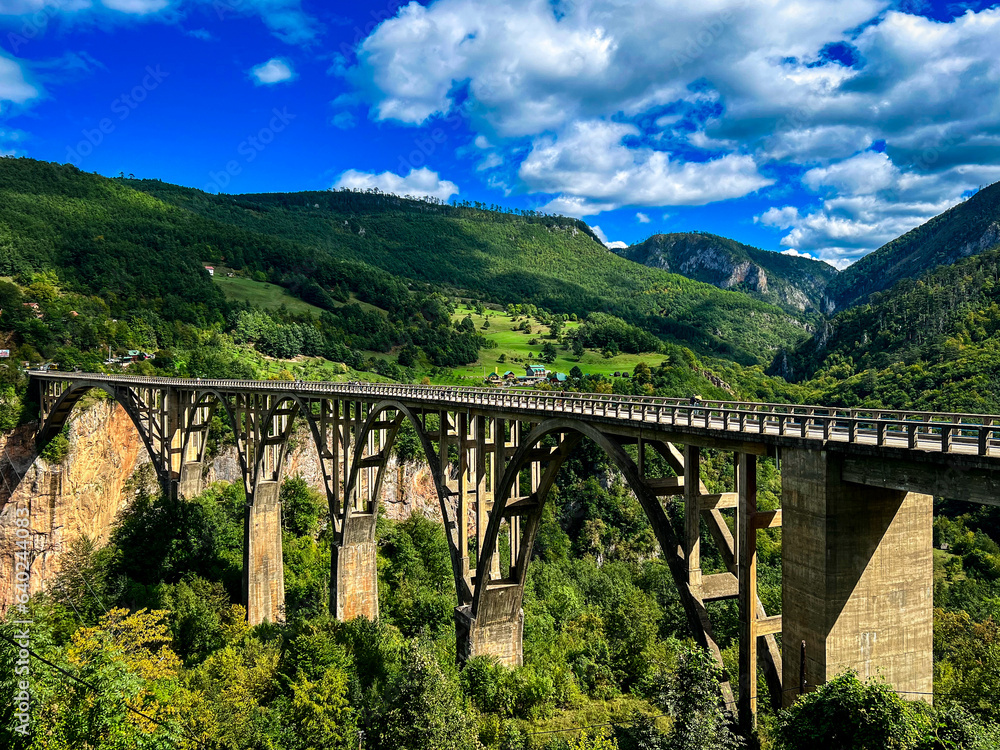 Bridge in Montenegro is embraced by majestic mountains and verdant greenery