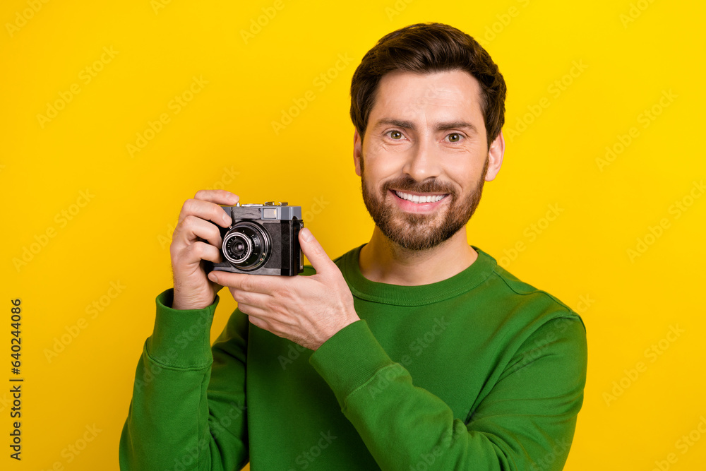 Photo of cheerful attractive man toothy smile wear trendy pullover like photographing digital camera isolated on yellow color background Photo of cheerful attractive man toothy smile wear trendy pullover like photographing digital camera isolated on yellow color background