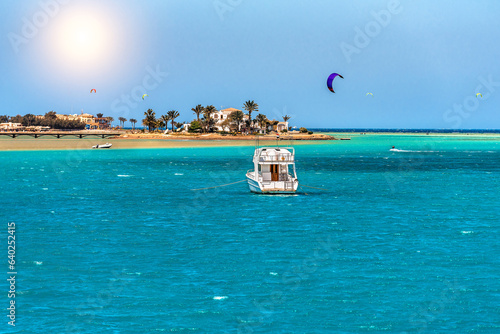 View of a yacht and a beautiful island and many kitesurfers on the Red Sea in Egypt