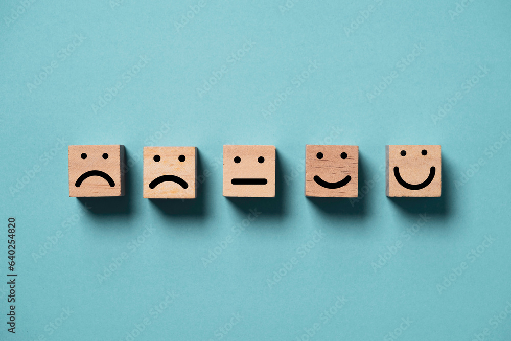 Obraz premium Human face from sad to smile print screen on wooden block cube face on blue background for positive thinking and excellent evaluation rating after use product and service concept.