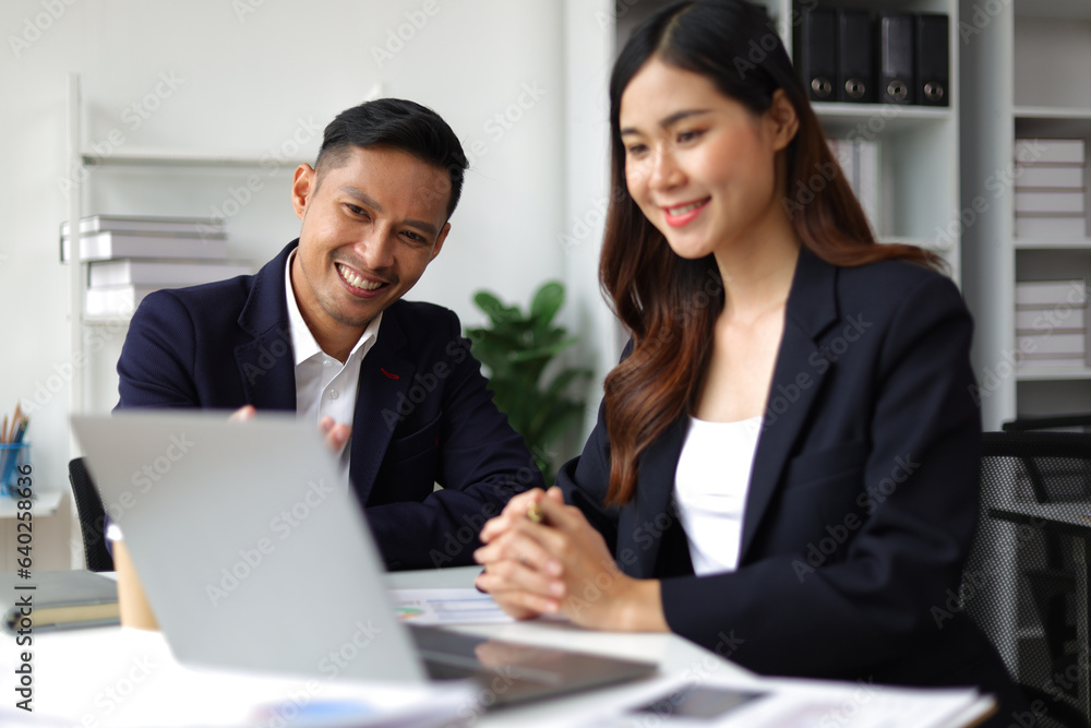 Boss and secretary working on documents together in office. Businessman and colleagues discussing in office collaboration.