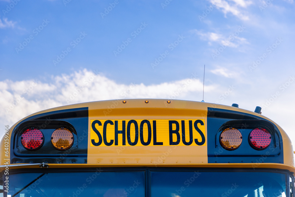 Yellow school bus with blue sky negative space