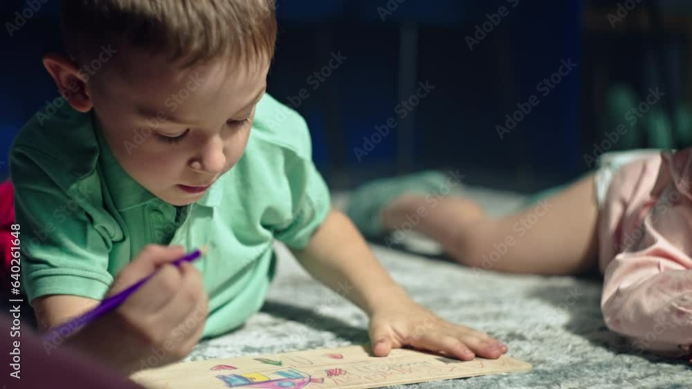 Capturing Childhood Magic: A Curious Boy Engaged in Pencil Sketching on Paper, Unleashing Artistic Talent, and Spreading Happiness. High quality 4k footage